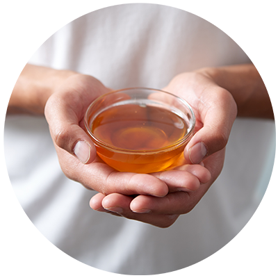 Honey ingredient being cradled in a bowl in hands, nothing artificial ever