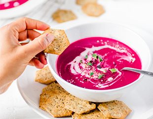 Beet soup being served with Sprouted Seed Crackers 
