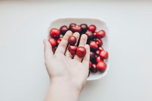 Cherries in bowl held in hands 